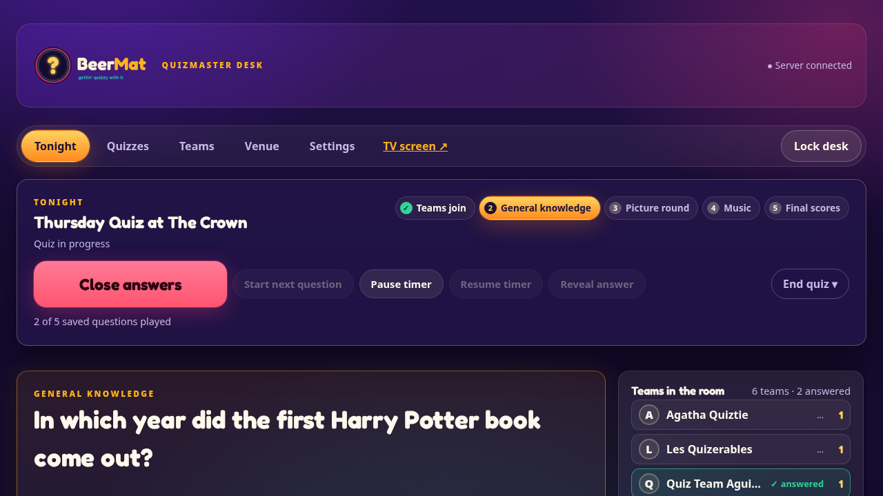 The quizmaster’s desk: the next question, teams in the room and their answers